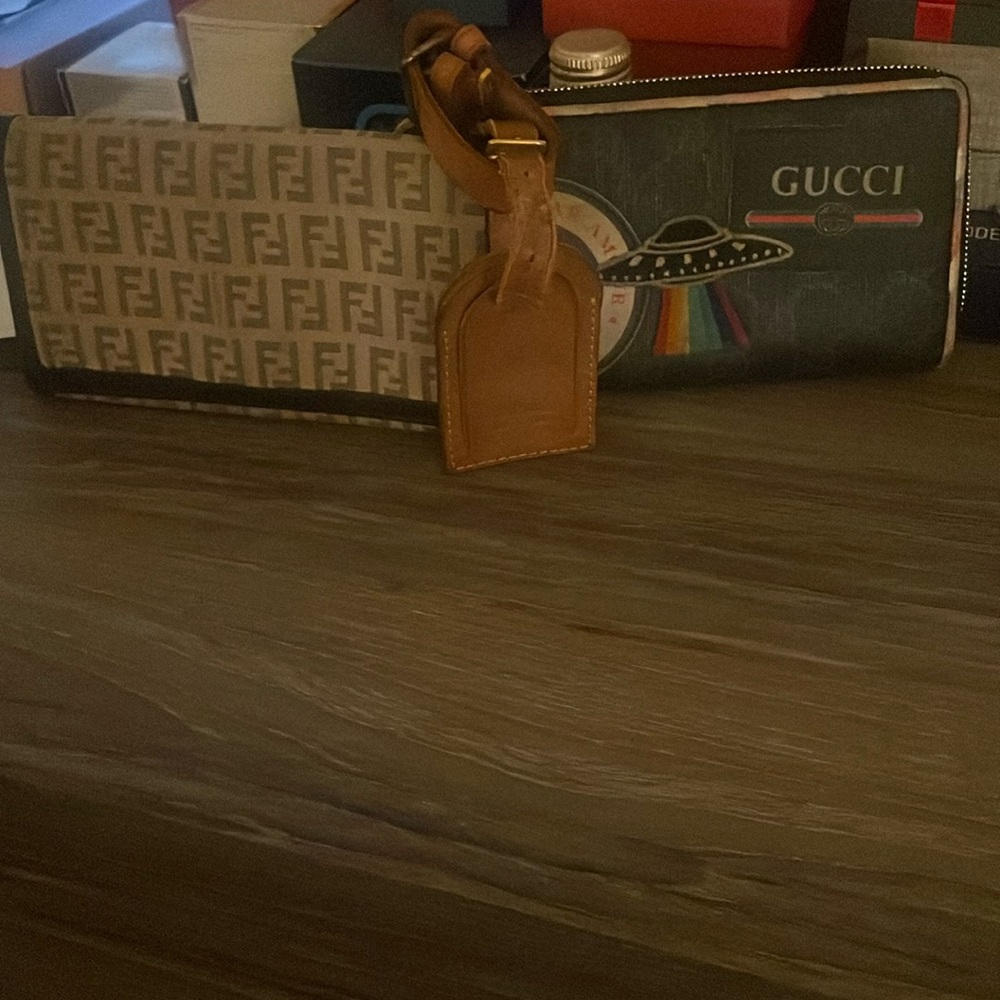 Two luxury wallets and a LV luggage tag